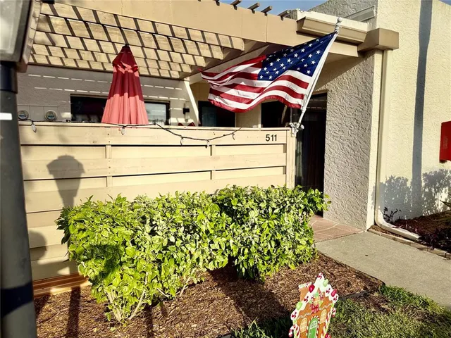 a view of a chairs and table under an umbrella in the garden
