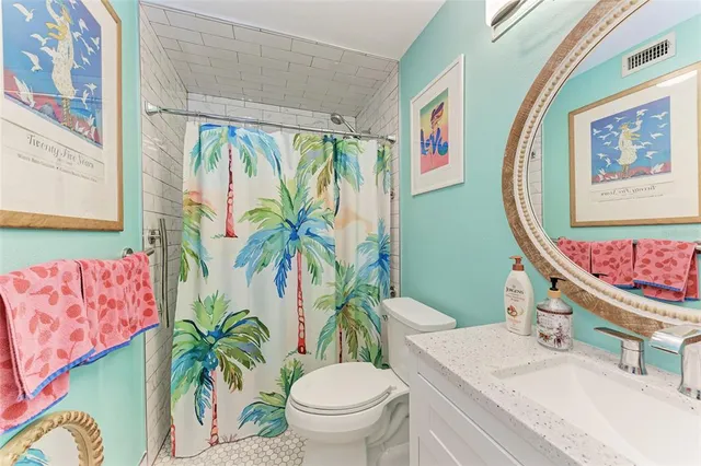 a living room with furniture potted plant and open kitchen view