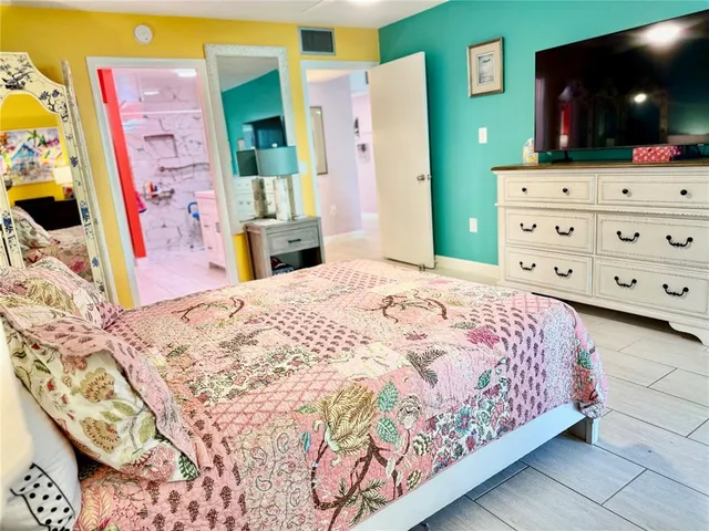 a bedroom with a bed dresser and a large mirror