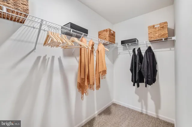 a view of walk in closet with clothes and shoes