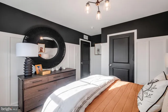 a bedroom with a bed and a mirror on the dresser