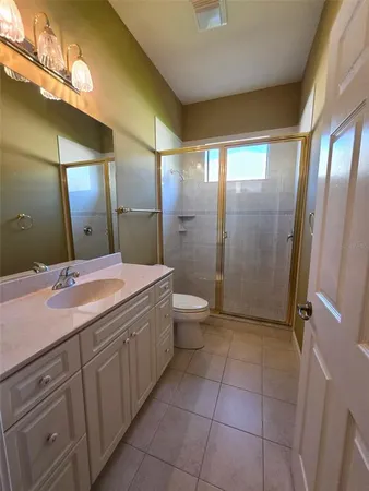 a bathroom with a double vanity sink toilet and shower