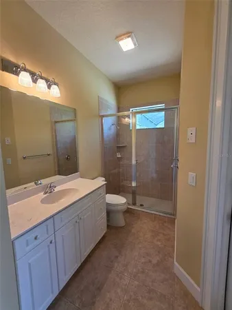 a spacious bathroom with a granite countertop sink toilet and shower