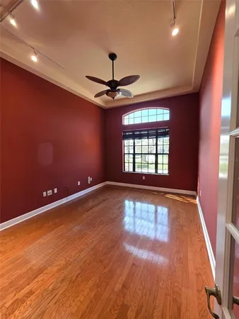 a view of an empty room with a window and wooden floor