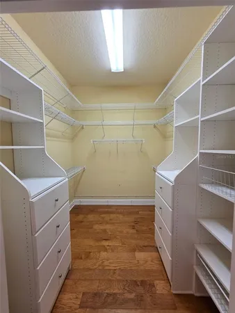 a view of walk in closet with empty racks
