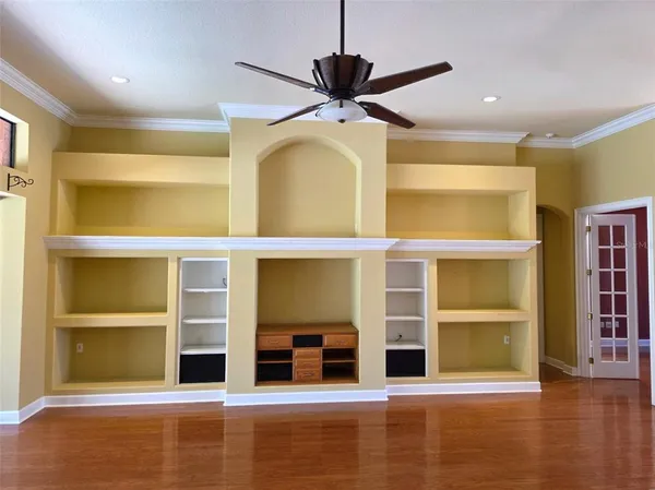 a view of a room with shelves and a ceiling fan