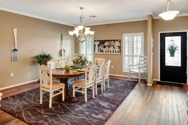 a kitchen with stainless steel appliances granite countertop a dining table chairs and granite counter tops