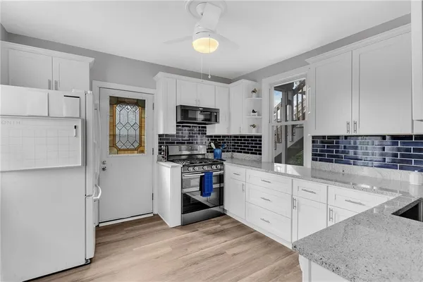 a kitchen with white cabinets and stainless steel appliances