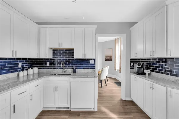a kitchen with stainless steel appliances a sink stove and cabinets