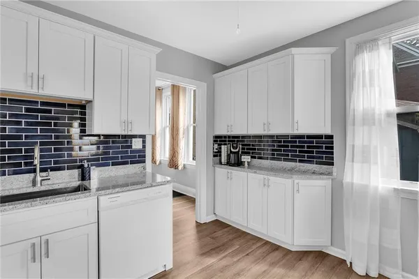 a kitchen with granite countertop white cabinets and white appliances