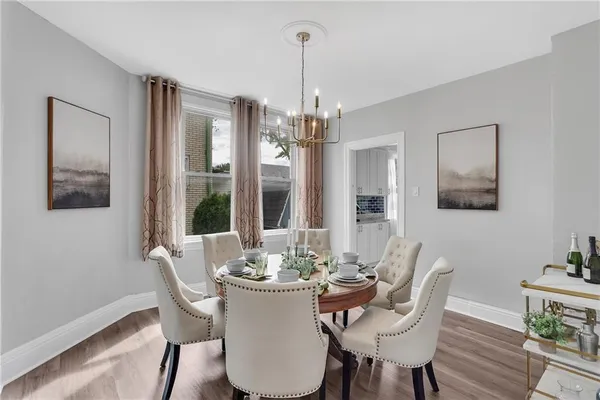 a dining room with furniture a chandelier and wooden floor