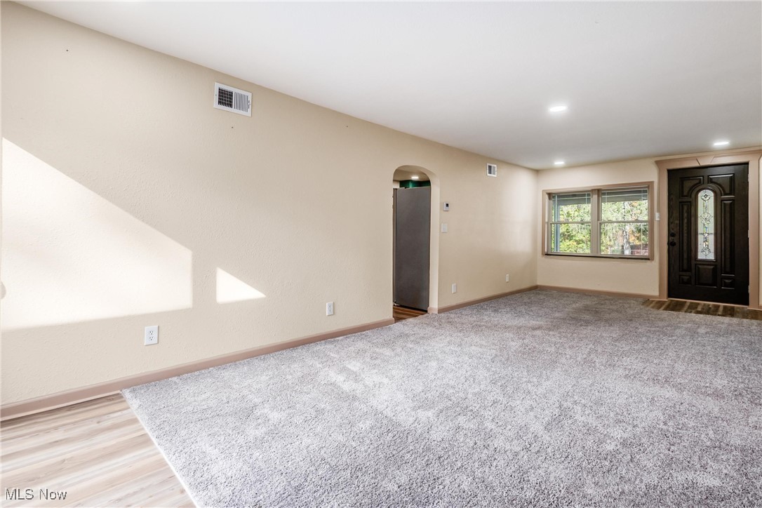 724 Garden Road Zanesville, OH 43701 - Photo 4 of 22 Unfurnished living room featuring arched walkways, recessed lighting, wood finished floors, and carpet