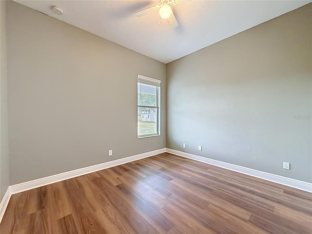 28549 Shirley Shores Road Tavares, FL 32778 - Photo 33 of 65 an empty room with wooden floor and windows