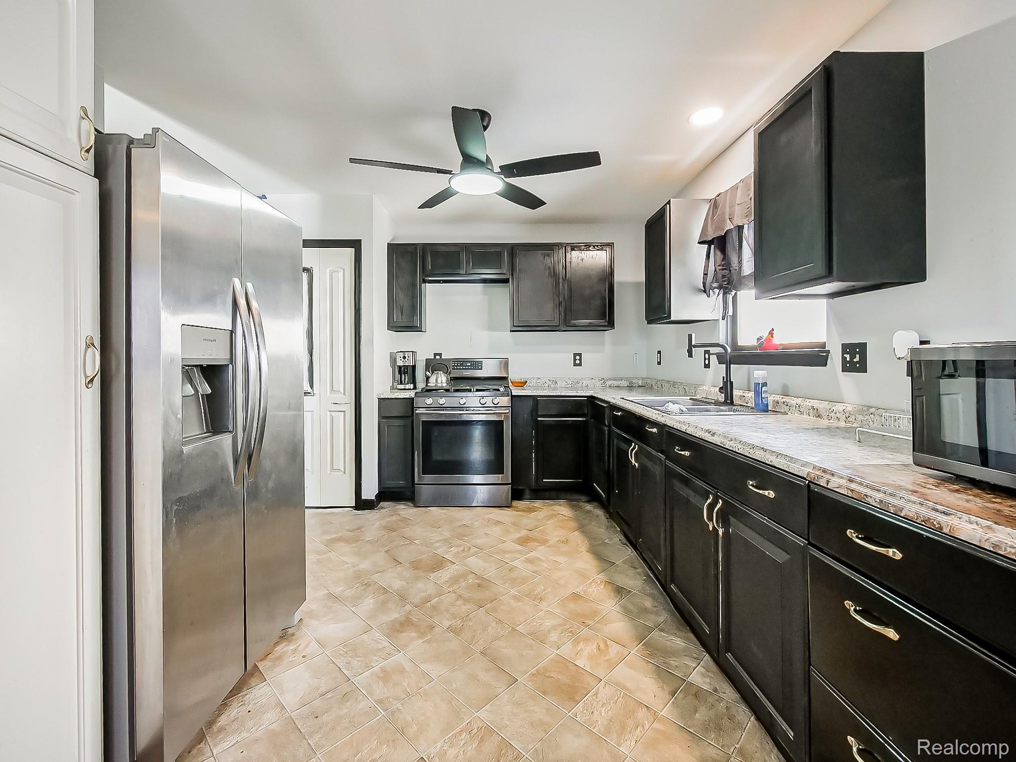 34460 Van Born Road Wayne, MI 48184 - Photo 4 of 31 Kitchen featuring stainless steel appliances, dark cabinetry, a ceiling fan, recessed lighting, and light stone counters