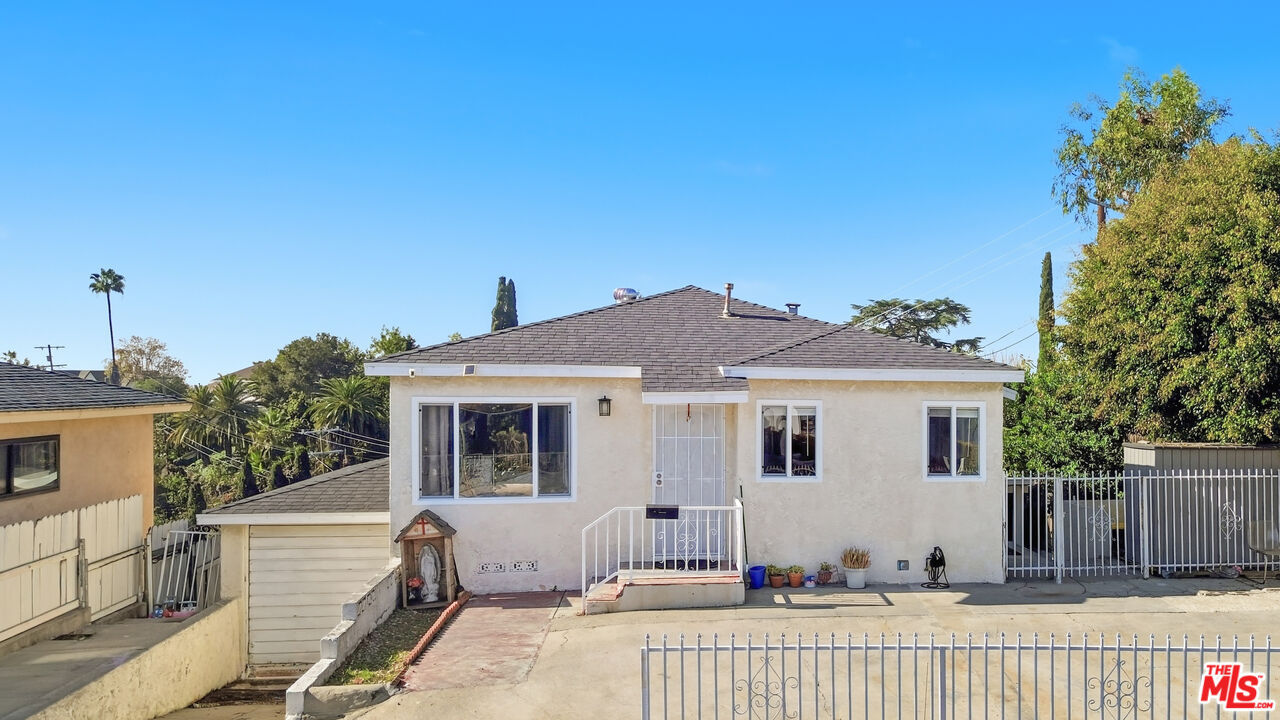 a view of a house with a wooden fence