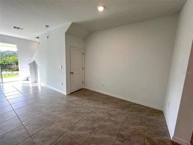 a view of an empty room with a fireplace and a window