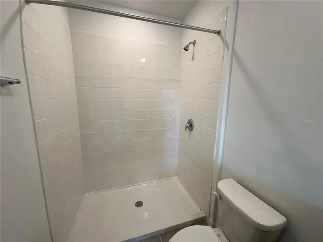 a bathroom with a granite countertop sink a toilet and bathtub