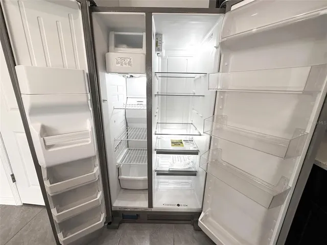 a kitchen with a sink a stove top oven a refrigerator with grey cabinets and wooden floor