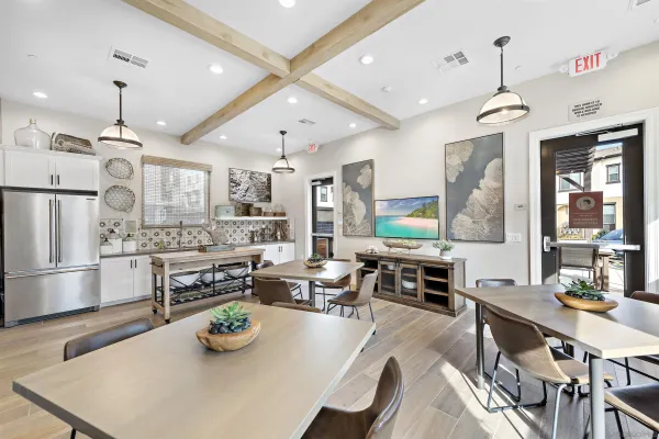 a kitchen with stainless steel appliances kitchen island granite countertop a stove a sink a dining table and chairs with wooden floor