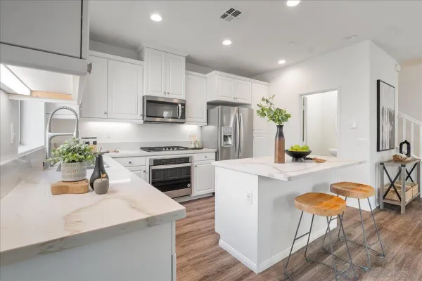 a kitchen with cabinets a counter and chairs