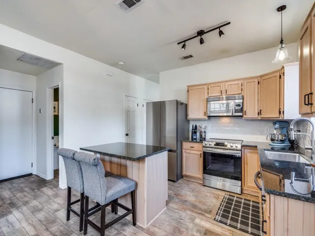 a kitchen with a stove a refrigerator and a stove top oven