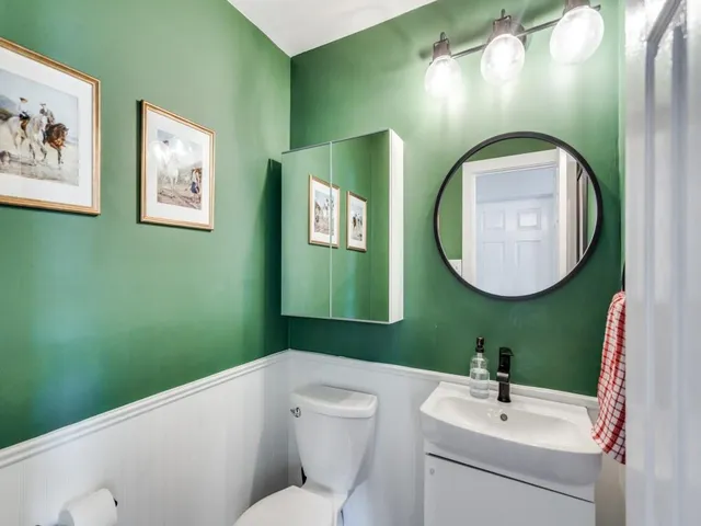 a bathroom with a toilet sink and mirror