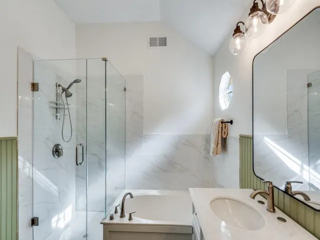 a bathroom with a sink a toilet a shower and a mirror