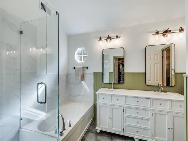 a bathroom with a double vanity sink mirror and shower