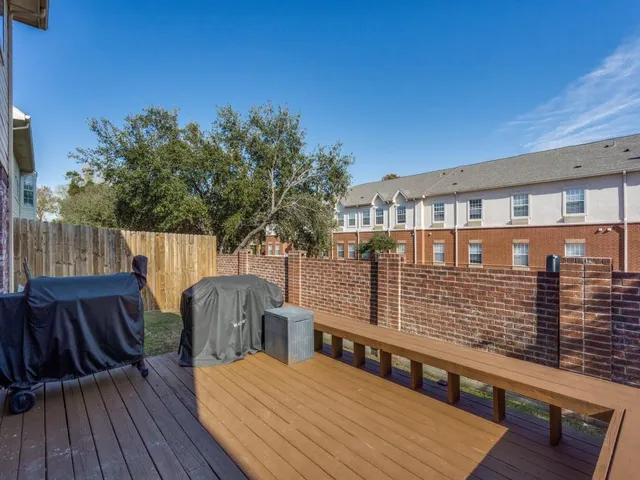 a view of a roof deck with table and chairs with wooden floor and fence
