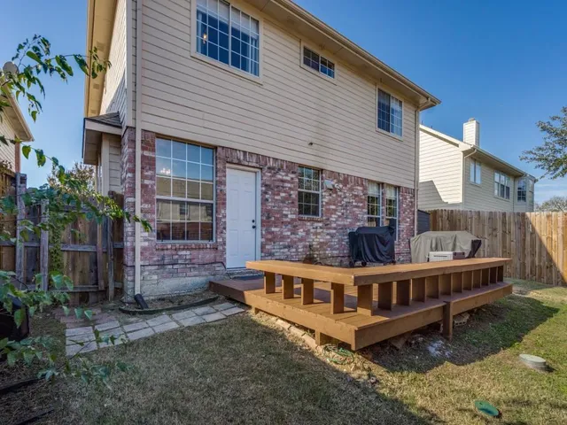 a view of a house with wooden deck and furniture