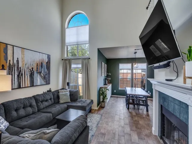 a living room with furniture a fireplace and a flat screen tv