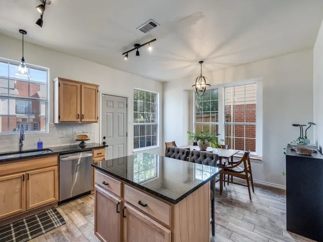 a kitchen with granite countertop a sink a counter space appliances and cabinets