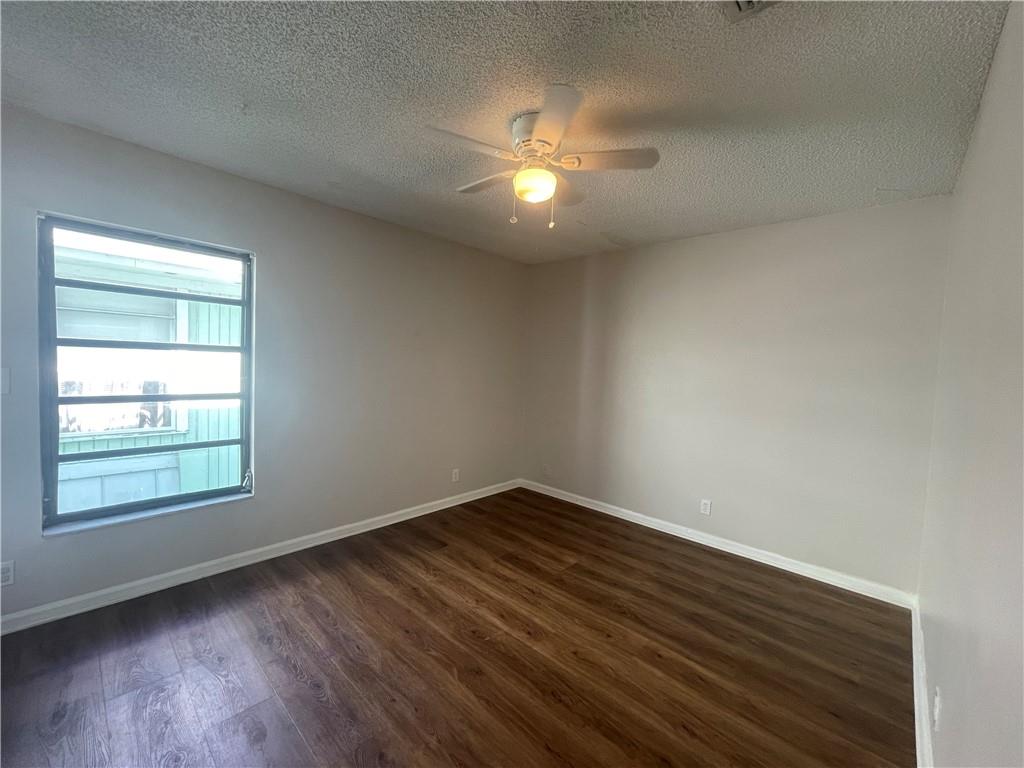 3601 Northeast 22nd Avenue Lighthouse Point, FL 33064 - Photo 12 of 13 an empty room with wooden floor ceiling fan and window