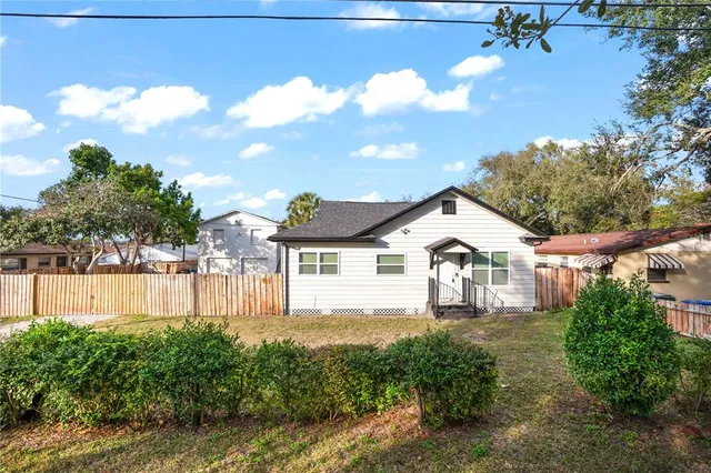 a view of a house with a big yard and large trees