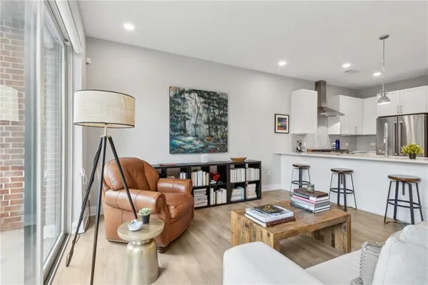 a living room kitchen with furniture and a wooden floor