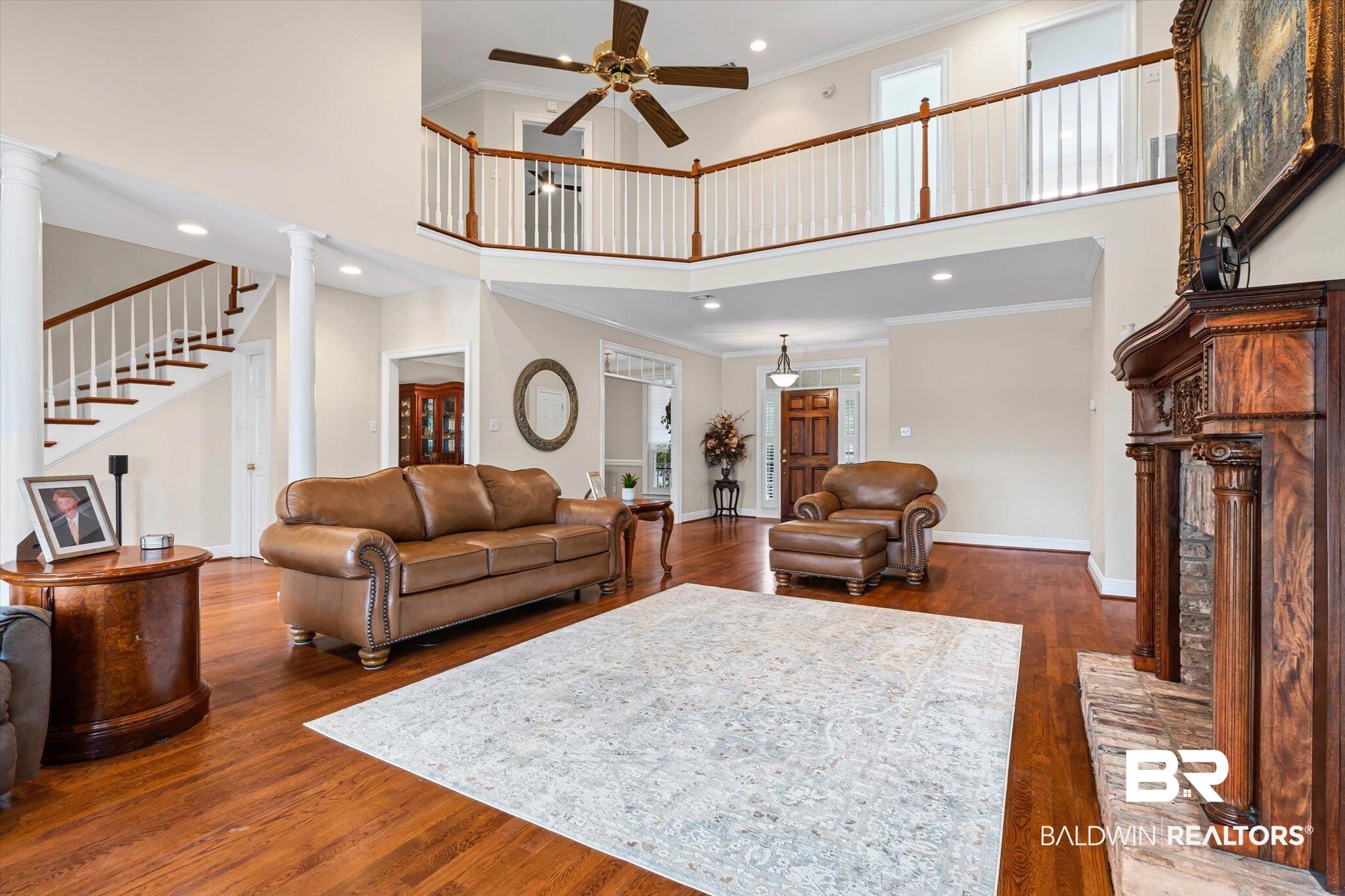 4851 Audubon Drive Mobile, AL 36619 - Photo 6 of 46 Living room featuring crown molding, a towering ceiling, dark wood-style floors, recessed lighting, and stairway