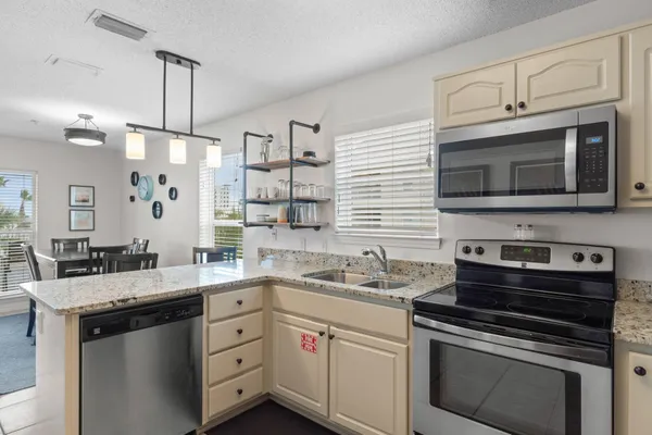 a kitchen with stainless steel appliances granite countertop a stove microwave and sink