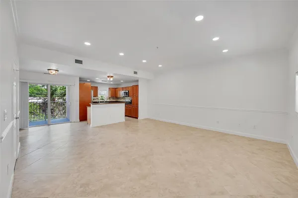 a view of an empty room with a kitchen
