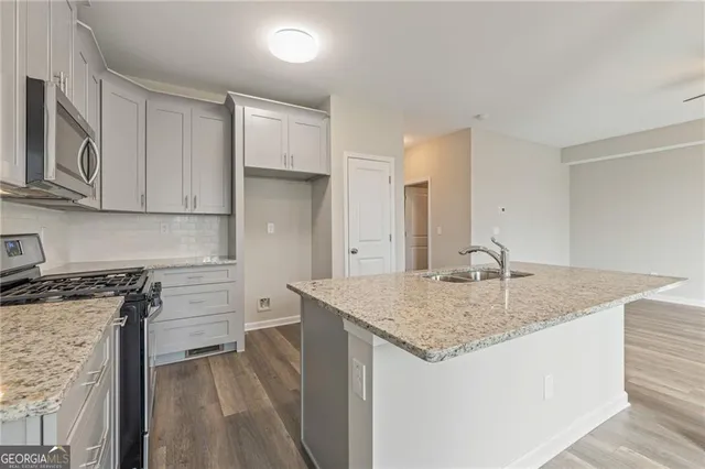 a kitchen with stainless steel appliances granite countertop a stove and a microwave