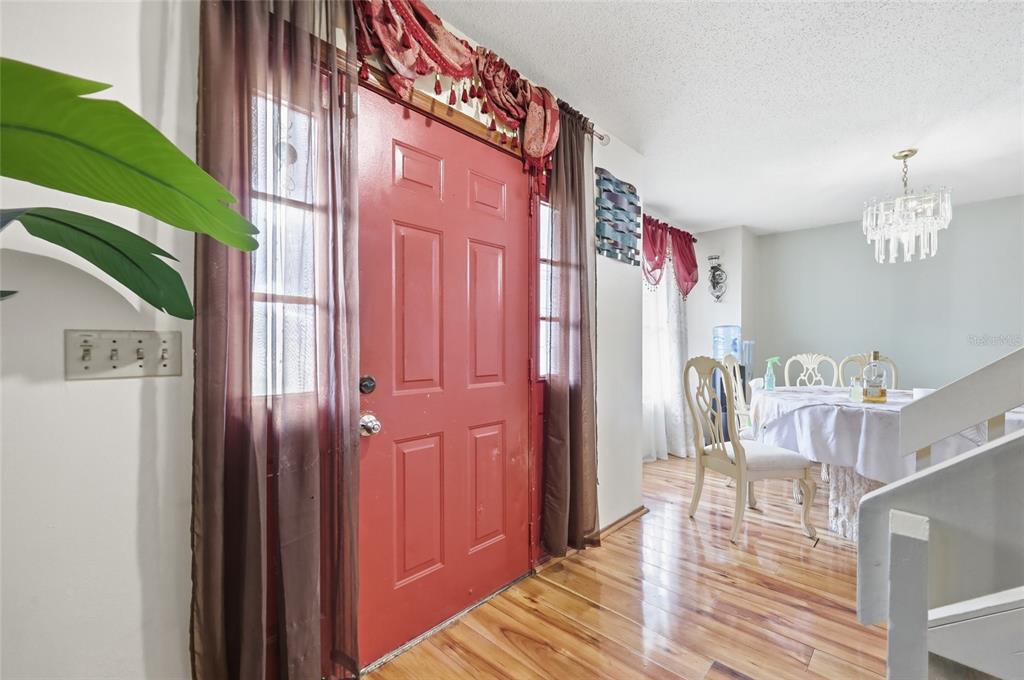 3027 Queens Gate Road Orlando, FL 32818 - Photo 7 of 34 a very nice looking room with a chair and wooden floor