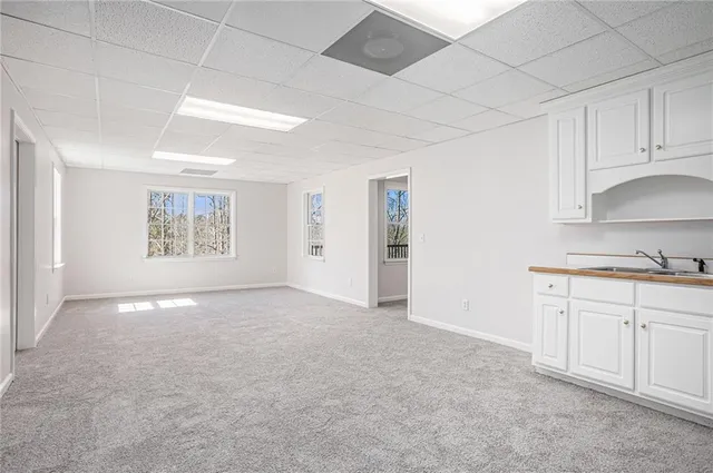 a view of an empty room with window and cabinet