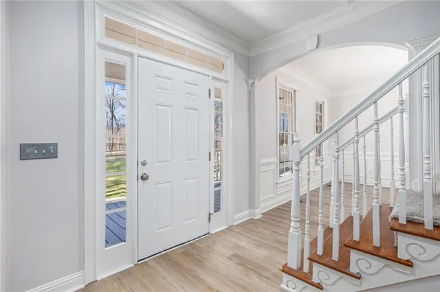 a view of a hallway with wooden floor and staircase