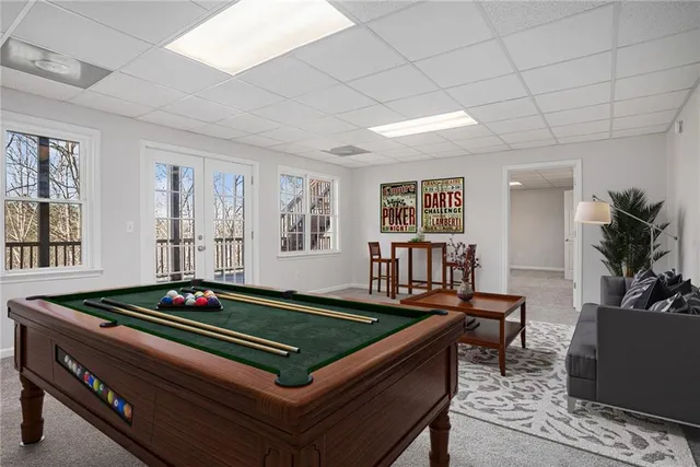 a living room with furniture pool table and window