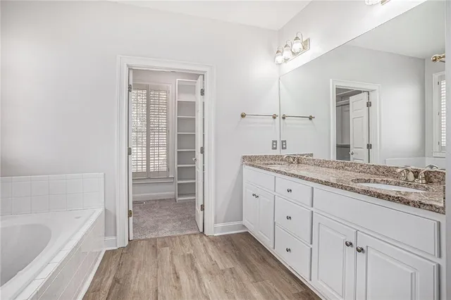 a bathroom with a granite countertop sink mirror and bathtub