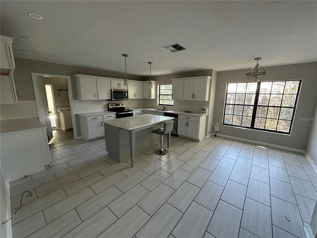 1423 Meadow Lark Road Spring Hill, FL 34606 - Photo 3 of 9 a kitchen with stainless steel appliances a sink a stove a refrigerator cabinets and a window