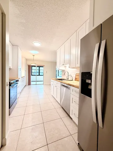 a kitchen with stainless steel appliances a refrigerator sink and cabinets