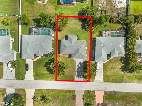 an aerial view of residential houses with outdoor space and swimming pool