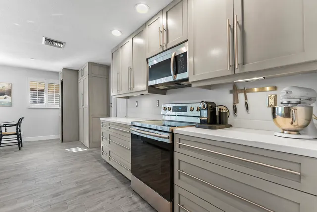 a large white kitchen with sink stove and white cabinets