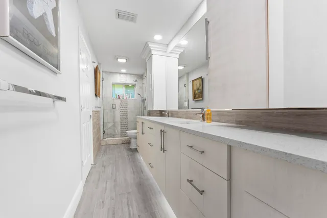 a spacious bathroom with a granite countertop sink a mirror and a bathtub