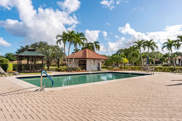a view of house with swimming pool and trees in the background